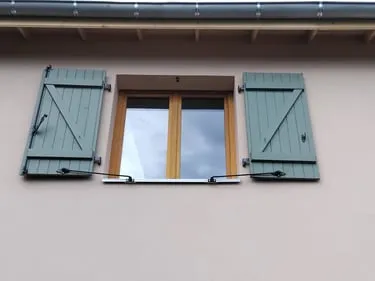 Volets bois peints en vert sage avec fenêtre bois naturel